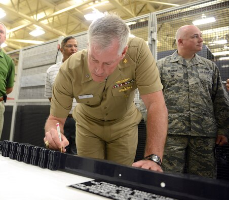 Capt. Matt Ott, Aviation Operations director with Naval Supply Systems Command, autographs a prototype manufactured by the 402nd Commodities Maintenance Group. Officials from the Navy and NORDAM, a global aerospace manufacturing and repair company, visited the 402nd CMXG, April 26, 2016, to celebrate a partnership that was formed in 2014 to manufacture F/A-18 outer wing panel spars to support NORDAM's F/A-18 Legacy Hornet wing repair lines.. (U.S. Air Force photo by Tommie Horton)