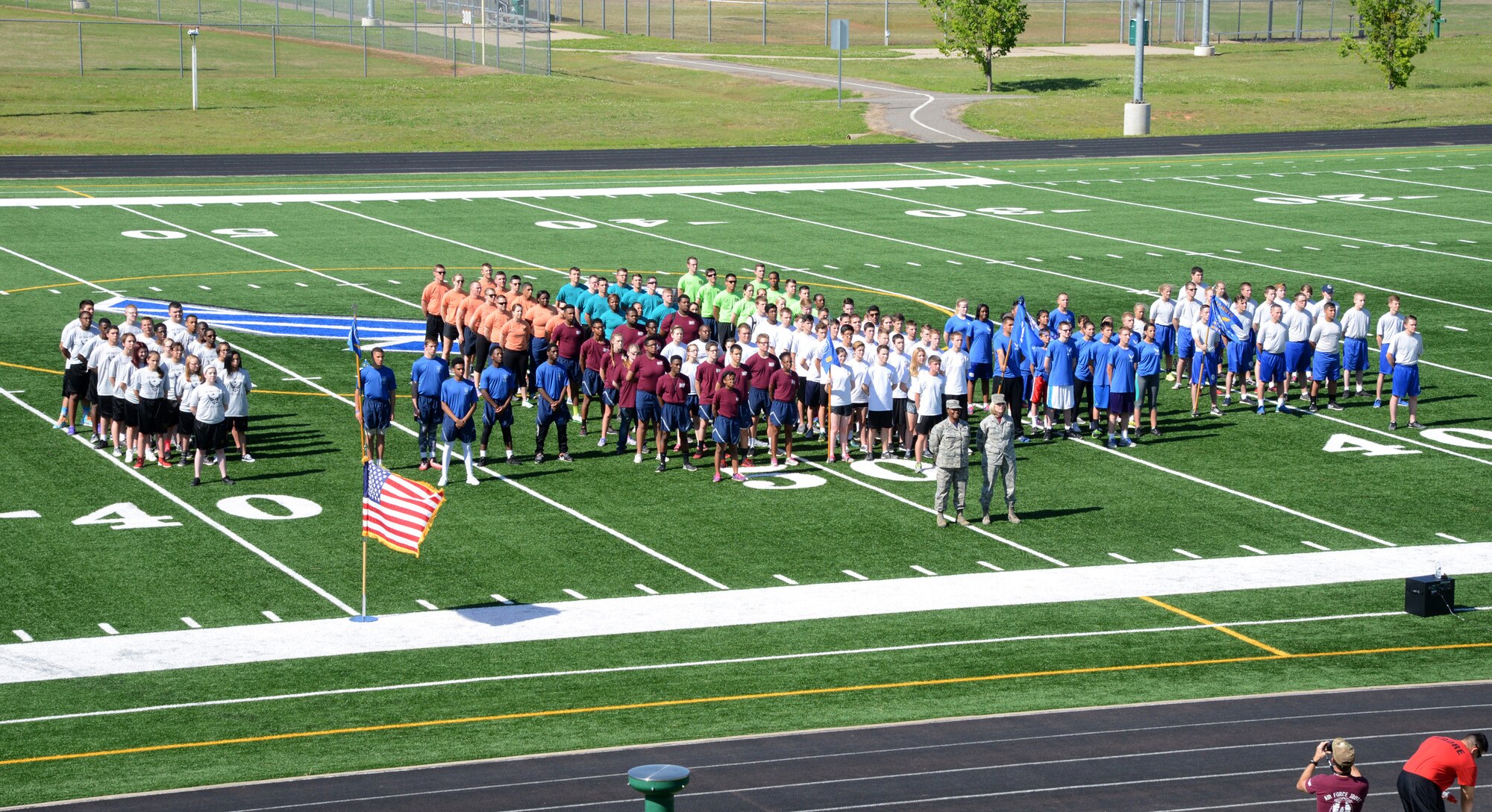 Cadets from six Air Force Junior Reserve Officer Training Corps units stand in formation before the start of the first-ever Tinker JROTC Community Outreach Event. The April 22 event was hosted by the 349th Recruiting Squadron as a way to emphasize citizenship and service. The cadets participated in events at the base track, including holding a plank position, sit-ups, push-ups, a relay race and tug-of-war. After the field events, the teams had a dodgeball tournament in the Gerrity Fitness Center, followed by pizza and drinks. An awards ceremony was held to find out the top teams of the events. The current class in the Airman Leadership School also participated in the event as part of their PT.  The event was sponsored by the Tinker First Sergeants Group, the Air Force Sergeants Association and Airforce.com. (Air Force photo by Kelly White/Released)