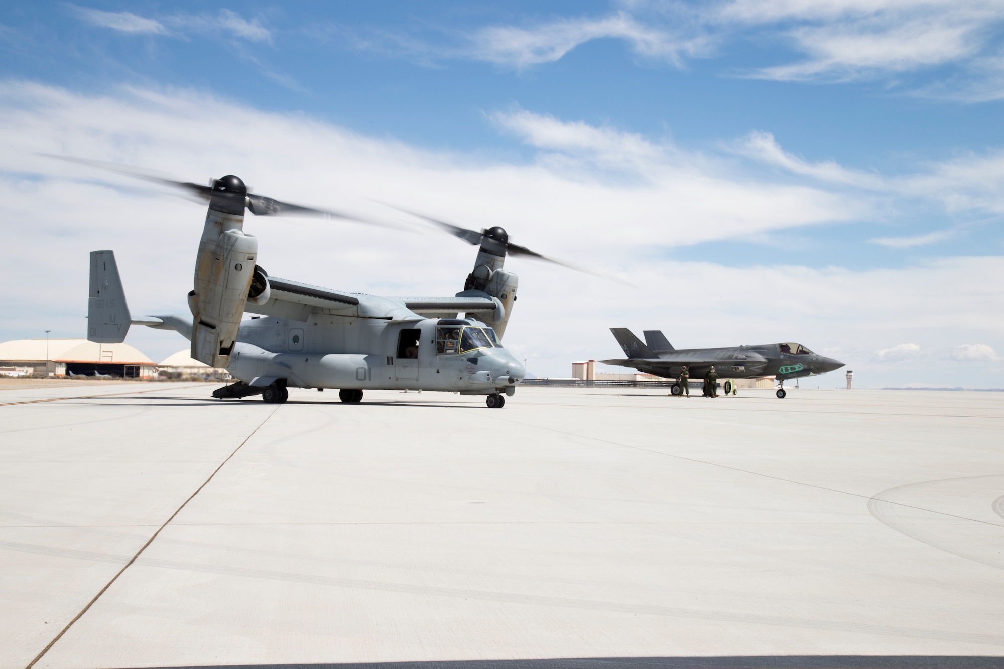 A U.S. Marine Corps MV-22B Osprey (left) descended on Edwards to link up with a Marine F-35B Joint Strike Fighter April 28. Both aircraft are assigned to Marine Operational Test & Evaluation Squadron 22 (VMX-22) out of Marine Corps Air Station Yuma in Arizona. The Osprey dropped by for a test to validate ground refueling from an MV-22 to an F-35B. (U.S. Air Force photo by Chris Higgins) 
