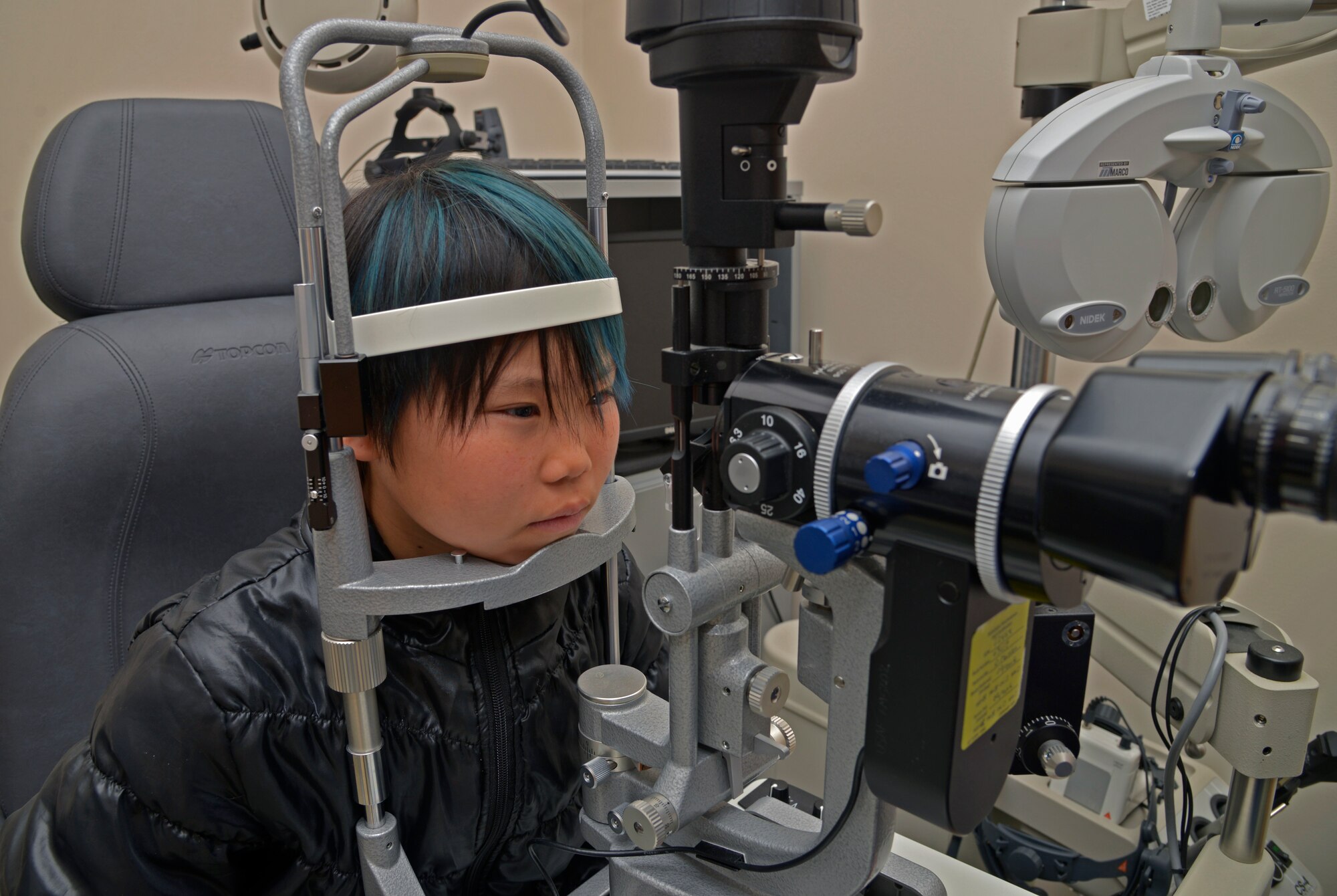 Seina Karr, 12, daughter of Tech Sgt. Ryan Karr, 374th Civil Engineer Squadron, rests her head to have her eyes examined at Yokota Air Base, Japan, April 26, 2016. The clinic provides diagnosis and treatment for vision and ocular disorders. (U.S. Air Force photo by Senior Airman David Owsianka/Released)
