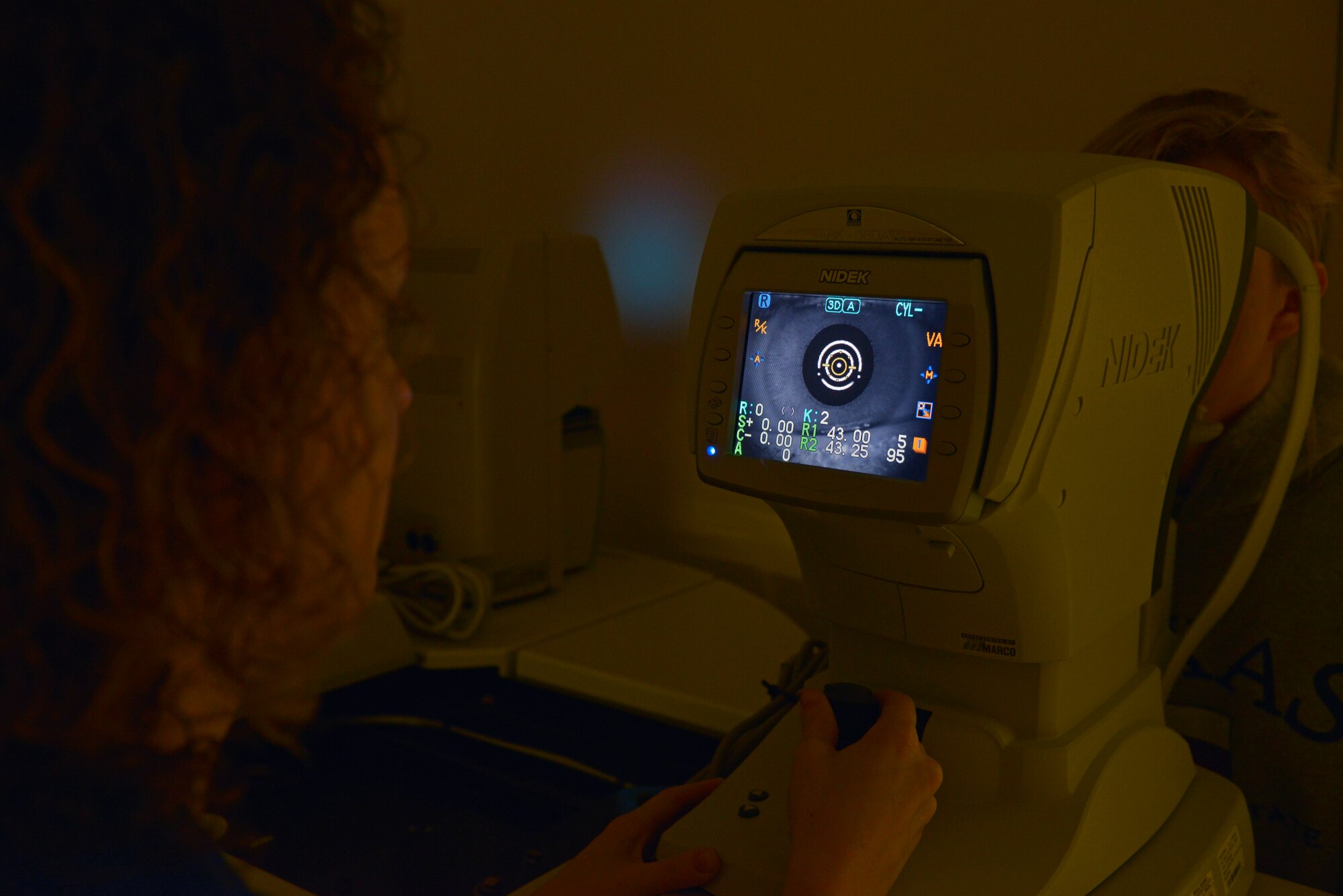 Kristen Judd, American Red Cross medical technician volunteer, uses an auto refractor machine to look at an eye of Teresa Talley, 19, daughter of Master Sgt. Thomas Talley, 374th Logistics Readiness Squadron fuels mobility support section chief, to make sure they are equal in size at Yokota Air Base, Japan, April 26, 2016. The clinic provides diagnosis and treatment for vision and ocular disorders. (U.S. Air Force photo by Senior Airman David Owsianka/Released)