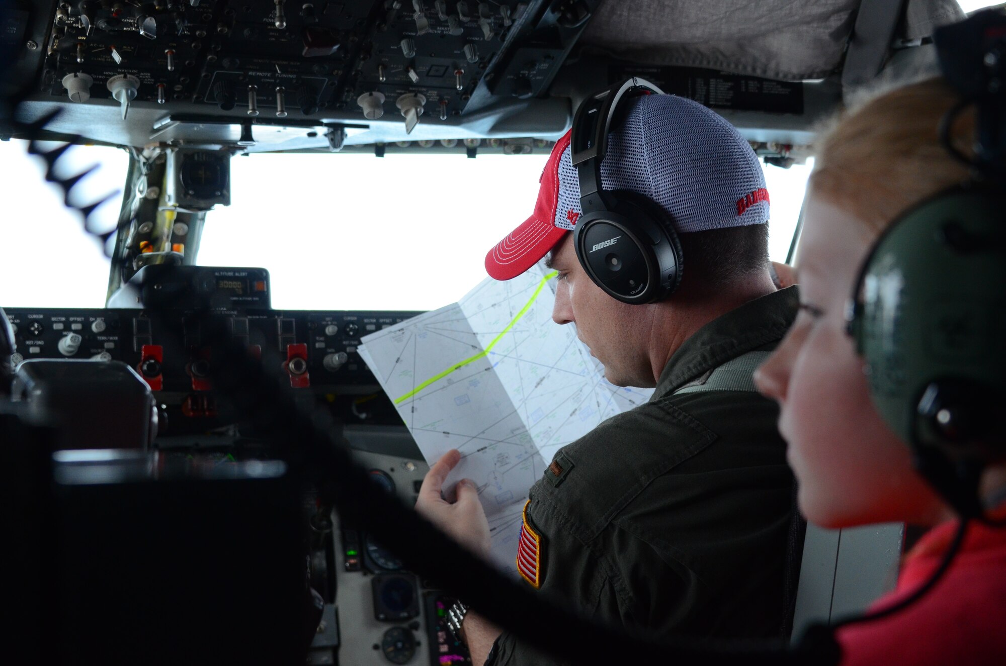 Second Lt. Jay R. Lamb, a pilot with the 128th Air Refueling Wing consults a map with pilot trainer Maj. Chad Hembrook during a flight from the 128th Air Refueling Wing, Milwaukee to Joint Base Pearl Harbor Hickam, Hawaii. The 128 ARW aircrew flew a 6-day mission ready airlift to transport Maryland Air National Guard members from their training in Guam to their home base near Baltimore April 20-25, 2016. (U.S. Air National Guard photo by Tech. Sgt. Meghan Skrepenski/Released)