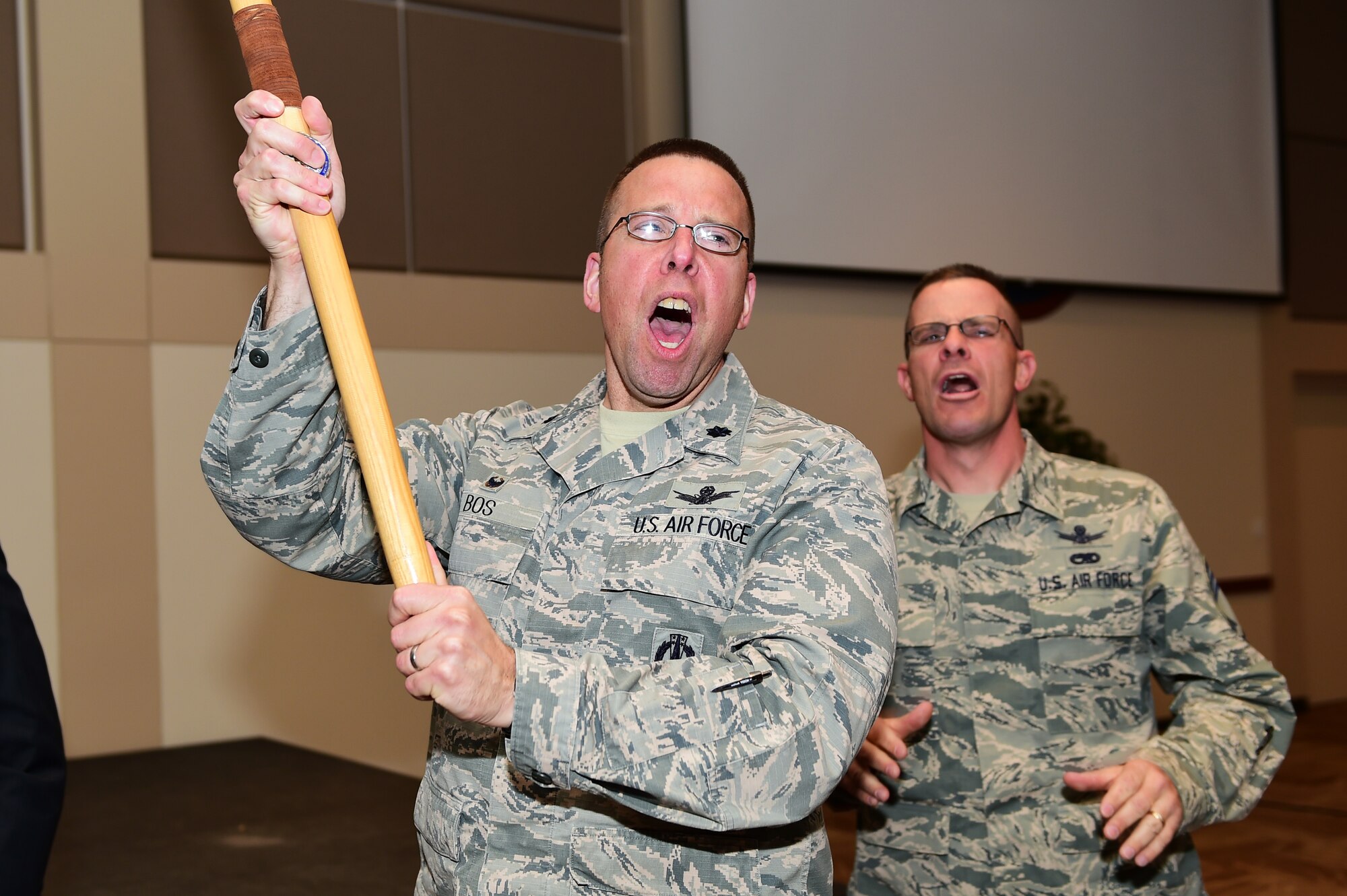 Lt. Col. Timothy Bos, 460th Operations Support Squadron commander, and Chief Master Sgt. Joseph Stratil, 460th Operations Group superintendent,  yell the Operations Group chant after winning the spirit stick during the 460th Space Wing first quarter award ceremony April 28, 2016, at the Leadership Development Center on Buckley Air Force Base, Colo. The spirit stick is awarded to the group who shows the most esprit de corps during the ceremony. (U.S. Air Force photo by Senior Airman Racheal E. Watson/Released)  
