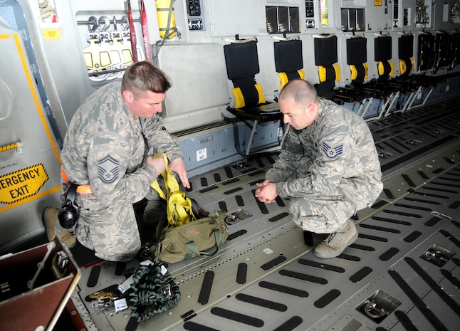 Senior Master Sgt. John Mursu, a Unit Effectiveness Inspection crew chief inspector, examines the harnesses on a C-17 Globemaster III at Joint Base Charleston April 13, 2016. A Unit Effectiveness Inspection is a two year process to ensure each wing is running at an effective level. (U.S. Air Force Photo/Airman Megan Munoz)