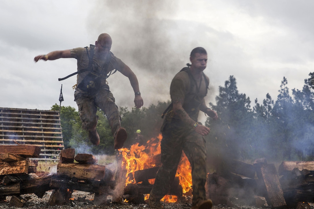 Army Rangers jump over smoldering logs at the Spartan event during Best Ranger Competition 2016 at Fort Benning, Ga., April 16, 2016. Army photo by Spc. Tracy McKithern