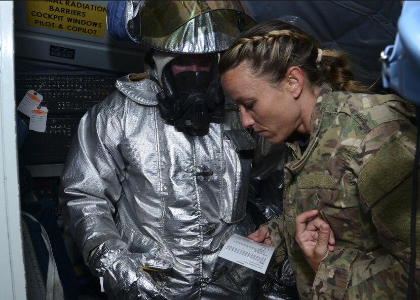 An Airman from the 379th Expeditionary Civil Engineer Squadron Fire Department escorts out a patient from a KC-135 Stratotanker during a Major Accident Recovery Exercise April 26, 2016, at Al Udeid Air Base, Qatar. Emergency responders to include Airmen from security forces, command and control, fire department, and medical, were put into action to aid and recover personnel during a simulated KC-135 Stratotanker mishap. (U.S. Air Force photo/Senior Airman Janelle Patiño/Released)