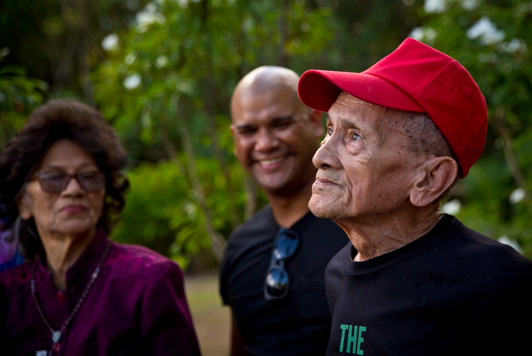 YONA, Guam (July 24, 2016) – Juan Guzman, a survivor of the Manenggon concentration camp, plants the Manenggon survivors flag during the Manenggon Memorial Foundation Memorial. Fellow U.S. Service members and the community of Guam gathered at Manenggon to honor the survivors and those that passed away during occupation in World War II. Manenggon was the site of a concentration camp during occupation. The citizens of Guam were forcefully marched down to Manenggon and many Chamorros did not make the journey.