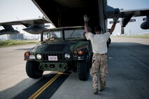 U.S. Air Force Staff Sgt. Shaun Larue, 1st Special Operations Squadron MC-130H Combat Talon II loadmaster assigned to Kadena Air Base, Japan, guides a Humvee assigned to 2nd Battalion, 2nd Marine Regiment, Marine Corps Base Camp Lejeune, N.C., out of his MC-130 cargo bay July 19, 2016, at Marine Corps Air Station Iwakuni, Japan. Larue trained the Marines how to safely load, secure, shackle and unload their Humvee in and out of the MC-130 in preparation for a long-range airfield seizure exercise. (U.S. Air Force Photo by Senior Airman Peter Reft) 