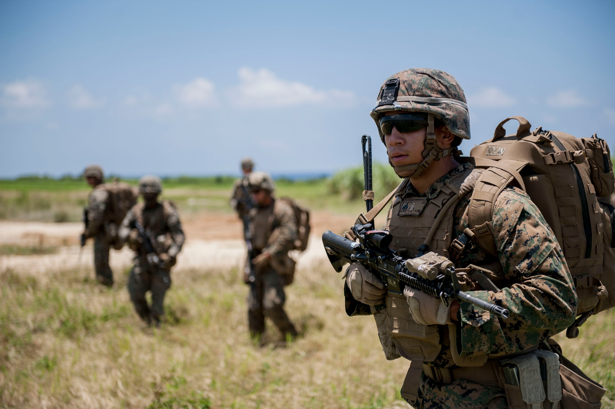 U.S. Marine Corps Cpl. James Ellis, Golf Company, 2nd Battalion, 2nd Marine Regiment squad leader assigned to Marine Corps Base Camp Lejeune, N.C., leads his fire team toward an objective during an airfield seizure exercise July 20, 2016, at Iejima airfield, Japan. Ellis and other Marines of Golf Company performed a simulated airfield seizure at Iejima to test their capability for a long-range joint operation with the U.S. Air Force 353rd Special Operations Squadron assigned to Kadena Air Base, Japan. (U.S. Air Force Photo by Senior Airman Peter Reft) 