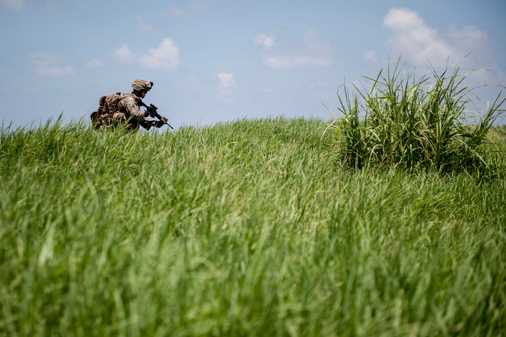 A U.S. Marine Corps rifleman assigned to Golf Company, 2nd Battalion, 2nd Marine Regiment, Marine Corps Base Camp Lejeune, N.C., navigates terrain during an airfield seizure exercise July 20, 2016, at Iejima airfield, Japan. Golf Company conducted their first long-range airfield seizure exercise with support from the Marine Medium Tiltrotor Squadron 265, Marine Corps Air Station Futenma, Japan and the U.S. Air Force 353rd Special Operations Group, Kadena Air Base, Japan. (U.S. Air Force Photo by Senior Airman Peter Reft) 