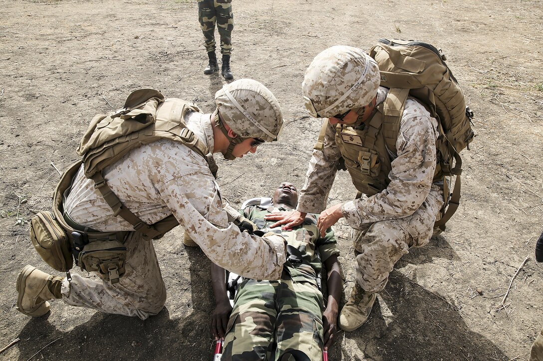 Lance Cpl. Thomas Jamieson and HM3 Vidal Rodriguez, a rifleman and corpsman with Special Purpose Marine-Air Ground Task Force Crisis Response-Africa, prep a simulated casualty to be transported to a helicopter during a medivac rehearsal with the Compagnie Fusilier de Marin Commando in Thies, Senegal, July 21, 2016. This is the first time Marines and the COFUMACO have used a helicopter for medical assistance during training in Senegal. This new capability saves valuable time should an injury occur during live-fire ranges.  (U.S. Marine Corps photo by 1st Lt. Eric Abrams /released)