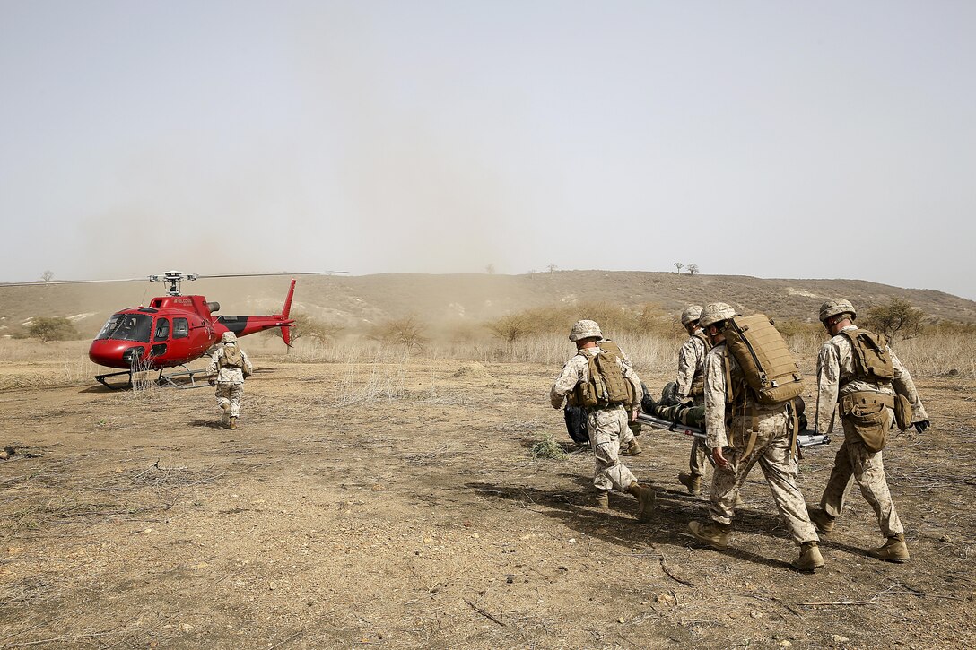U.S Marines with Special Purpose Marine Air-Ground Task Force Crisis Response-Africa move a simulated casualty to a helicopter during a medivac rehearsal with the Compagnie Fusilier de Marin Commando in Thies, Senegal, July 21, 2016. This is the first time Marines and the COFUMACO have used a helicopter for medical assistance during training in Senegal. This new capability saves valuable time should an injury occur during live-fire ranges. (U.S. Marine Corps photo by 1st Lt. Eric Abrams /released)