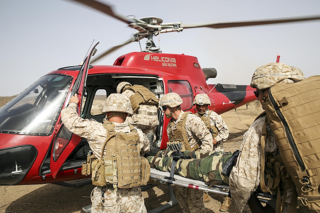 U.S Marines with Special Purpose Marine Air-Ground Task Force Crisis Response-Africa load a simulated casualty to a helicopter during a medivac rehearsal with the Compagnie Fusilier de Marin Commando in Thies, Senegal, July 21, 2016. This is the first time Marines and the COFUMACO have used a helicopter for medical assistance during training in Senegal. This new capability saves valuable time should an injury occur during live-fire ranges. (U.S. Marine Corps photo by 1st Lt. Eric Abrams /released)