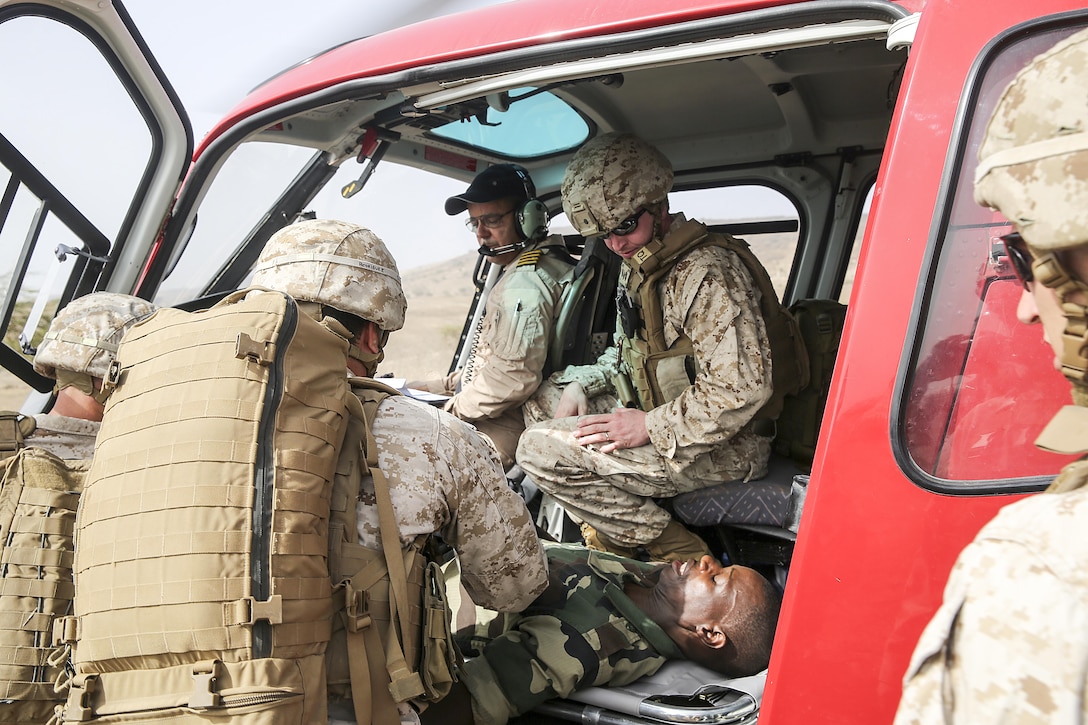 U.S Marines with Special Purpose Marine Air-Ground Task Force Crisis Response-Africa load a simulated casualty to a helicopter during a medivac rehearsal with the Compagnie Fusilier de Marin Commando in Thies, Senegal, July 21, 2016. This is the first time Marines and the COFUMACO have used a helicopter for medical assistance during training in Senegal. This new capability saves valuable time should an injury occur during live-fire ranges. (U.S. Marine Corps photo by 1st Lt. Eric Abrams /released)