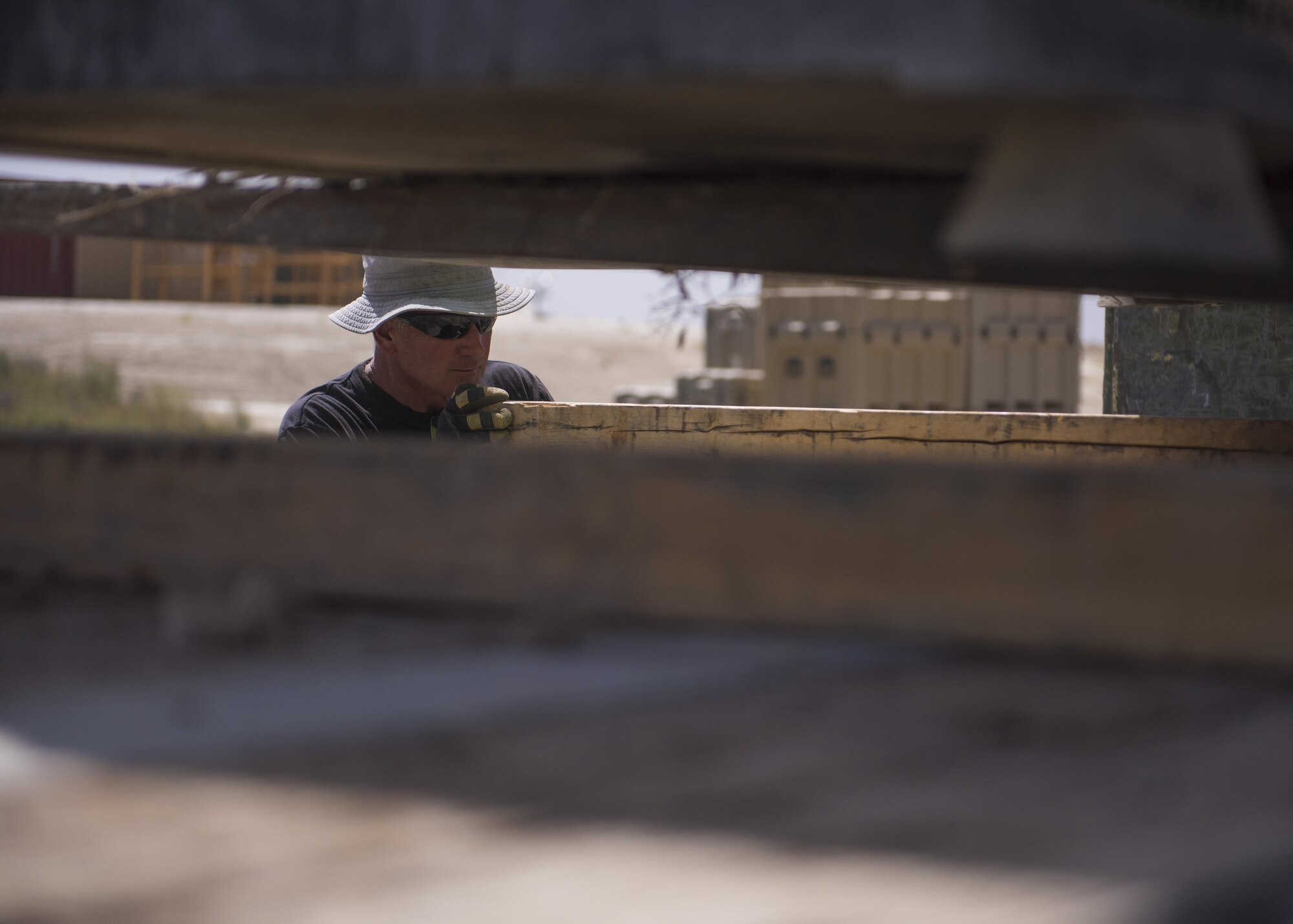 Rick Fisk, supply manager, places a 2x4 under a generator, Bagram Airfield, Afghanistan, Aug. 1, 2016. The generator will be taken to the base repair center to be fixed and used in the future. Logistic and supply provides equipment to security forces members throughout the base and 2 forward operating bases. (U.S. Air Force photo by Senior Airman Justyn M. Freeman)