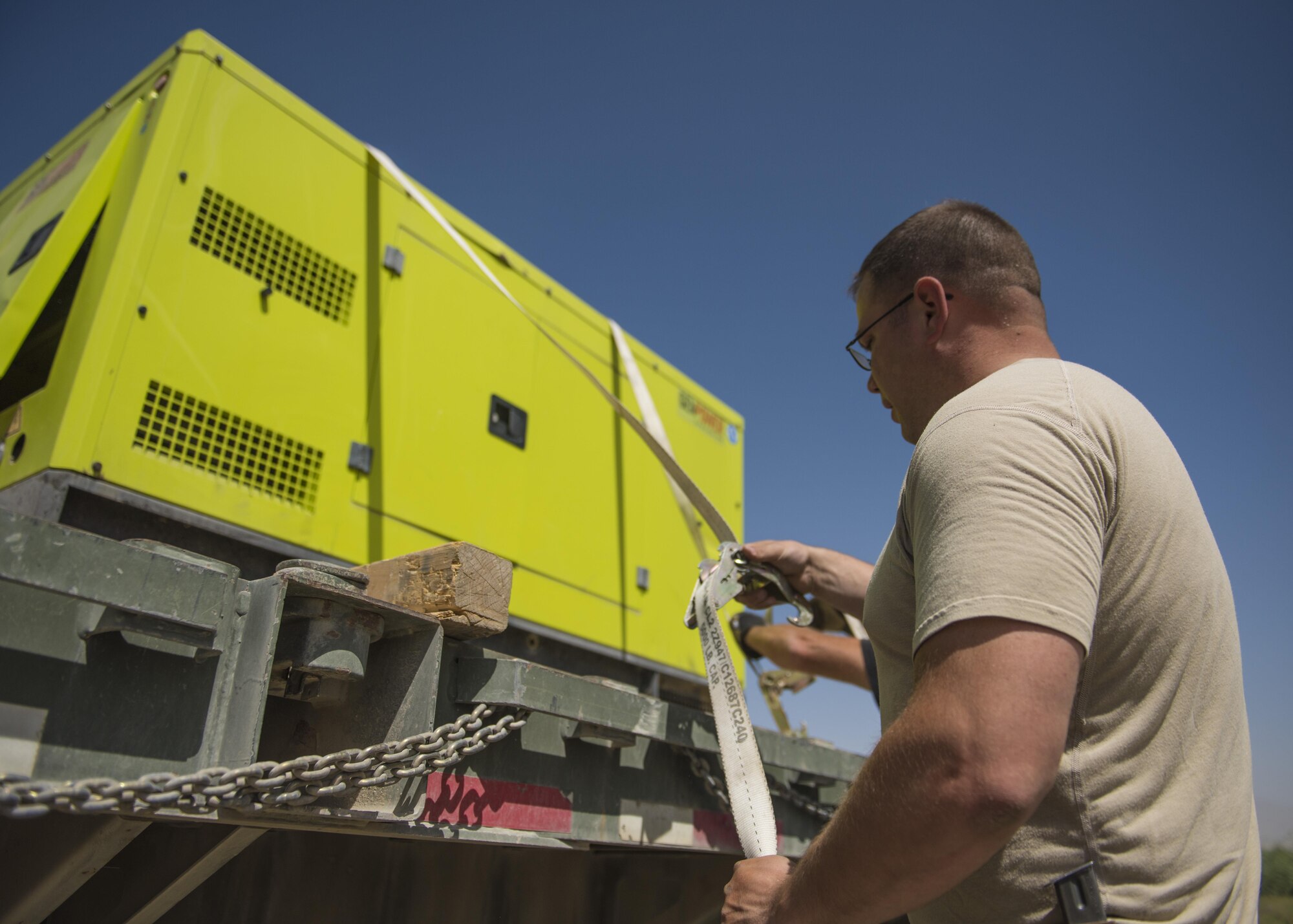Tech. Sgt. Timothy Cook, 455th Expeditionary Security Forces Squadron, supply and logistics noncommissioned officer in charge, straps down a generator to a flatbed truck, Bagram Airfield, Afghanistan, Aug. 1, 2016. The supply and logistics team use heavy machinery to transport equipment and supplies. They also provide all security units throughout the base and surrounding forward operating bases with equipment and supplies. (U.S. Air Force photo by Senior Airman Justyn M. Freeman)