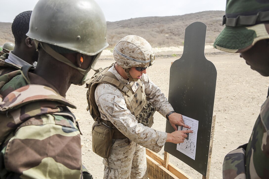 Sgt. Ryan Underwood, a rifleman with Special Purpose Marine Air-Ground Task Force Crisis Response-Africa, points out a shooting pattern during a live-fire training exercise with the Compagnie Fusilier de Marin Commando in Thies, Senegal, July 22, 2016. Marines and the COFUMACO conducted a three-week training exercise that included advanced combat firing techniques, a machine gun range and a live-fire platoon attack range. (U.S. Marine Corps photo by 1st Lt. Eric Abrams /released)