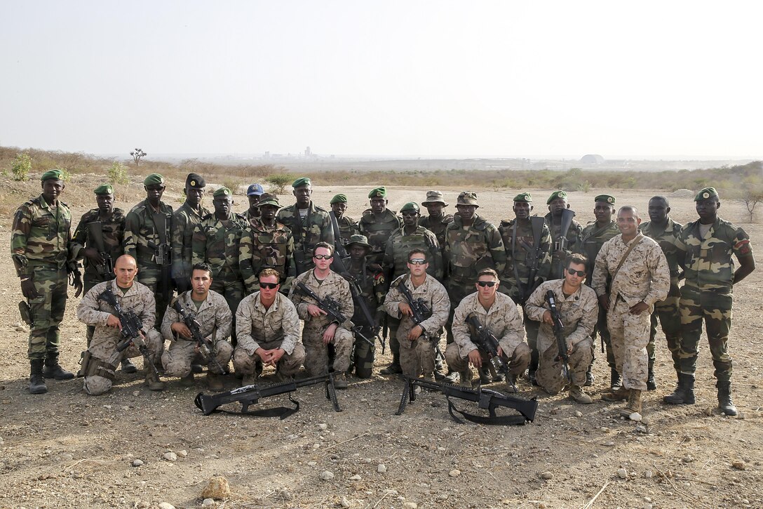 Marines with Special Purpose Marine Air-Ground Task Force Crisis Response-Africa conduct pose for a picture with the Compagnie Fusilier de Marin Commando in Thies, Senegal, July 22, 2016. Marines and the COFUMACO conducted a three-week training exercise that included advanced combat firing techniques, a machine gun range and a live-fire platoon attack range. (U.S. Marine Corps photo by 1st Lt. Eric Abrams)