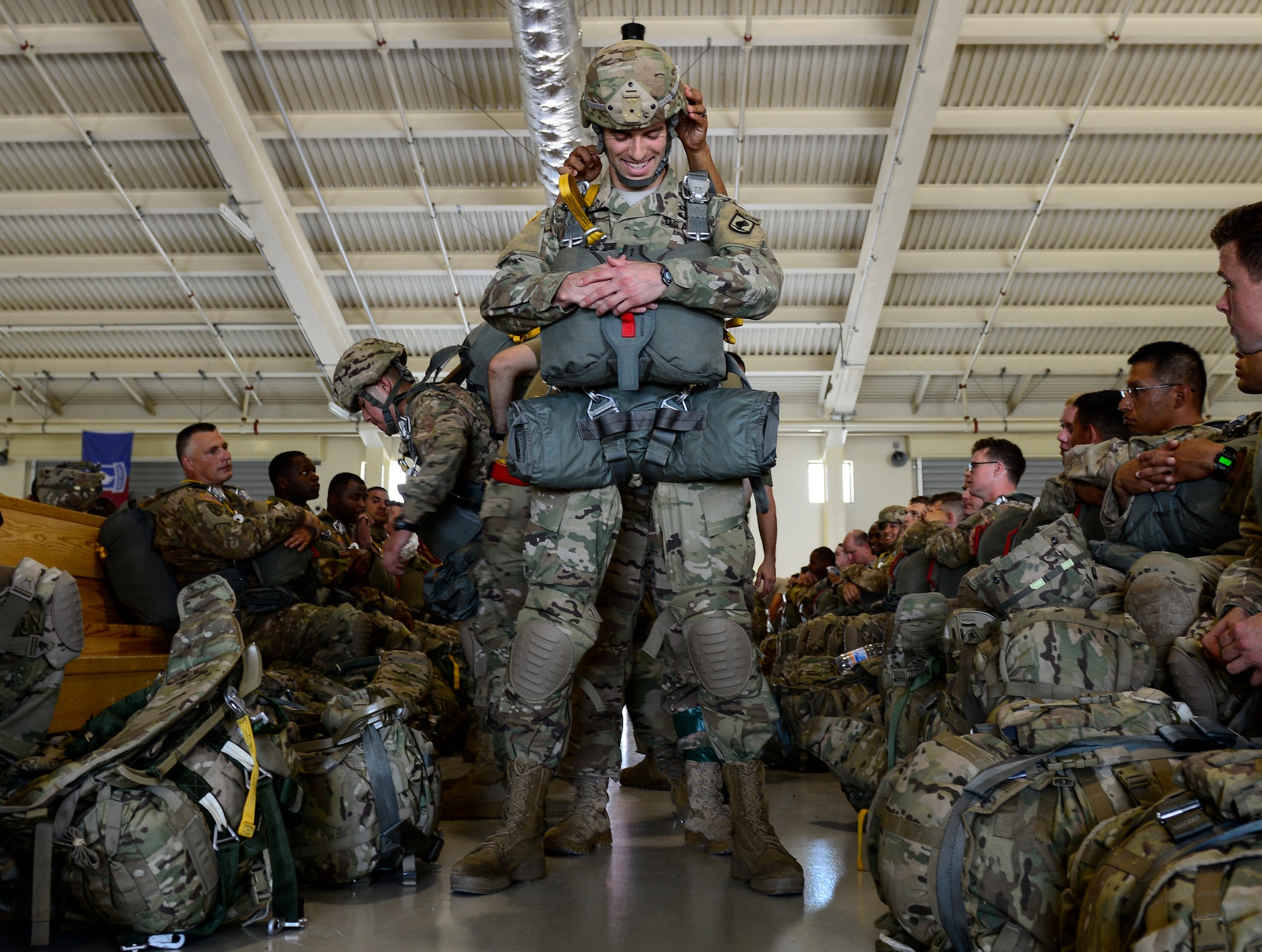U.S. Army 173rd Airborne Brigade paratroopers don the T-11 parachutes, July 27, 2016, prior to executing airborne operations at Aviano Air Base in Italy. Paratroopers regular participate in jumps to ensure all operational training requirements are maintained year round. The 173rd Airborne Brigade from Vicenza, Italy, is the Army Contingency Response Force in Europe. They are capable of projecting forces to conduct a full range of military operations across the United States European, Central and Africa Command areas of responsibility. (U.S. Air Force photo by Senior Airman Krystal Ardrey/Released) 