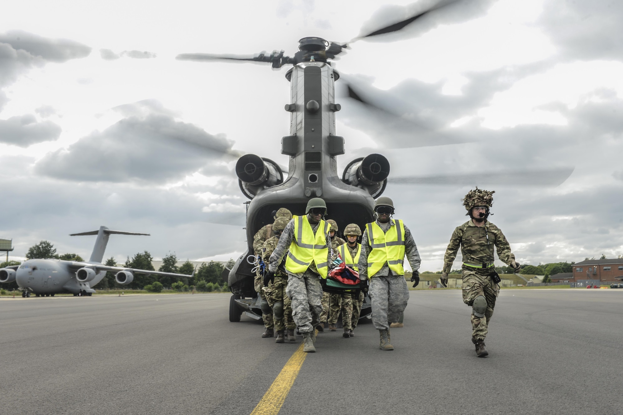 Joint-force medical personnel carry a simulated casualty from a CH-47 Chinook during exercise Combat Joint Atlantic Serpent at Royal Air Force Brize Norton, England, July, 25. CJAS is a week-long field training exercise where joint-force medical personnel conduct aeromedical evacuation simulations to  increase interoperability between partnering nations and services during the transfer of injured individuals. (U.S. Air Force photo /Senior Airman Nigel Sandridge)