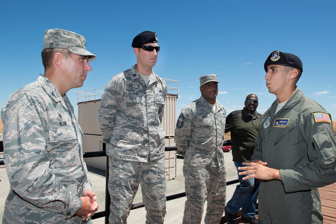 Air Force Col. John M. Klein Jr., left, commander of the 60th Air Mobility Wing, receives a briefing from Air Force Airman 1st Class Uriel Mendoza on his duty responsibilities before participating in a military working dog demonstration at Travis Air Force Base, Calif., July 21, 2016. Mendoza is assigned to the 60th Security Forces Squadron. Air Force photo by Louis Briscese 