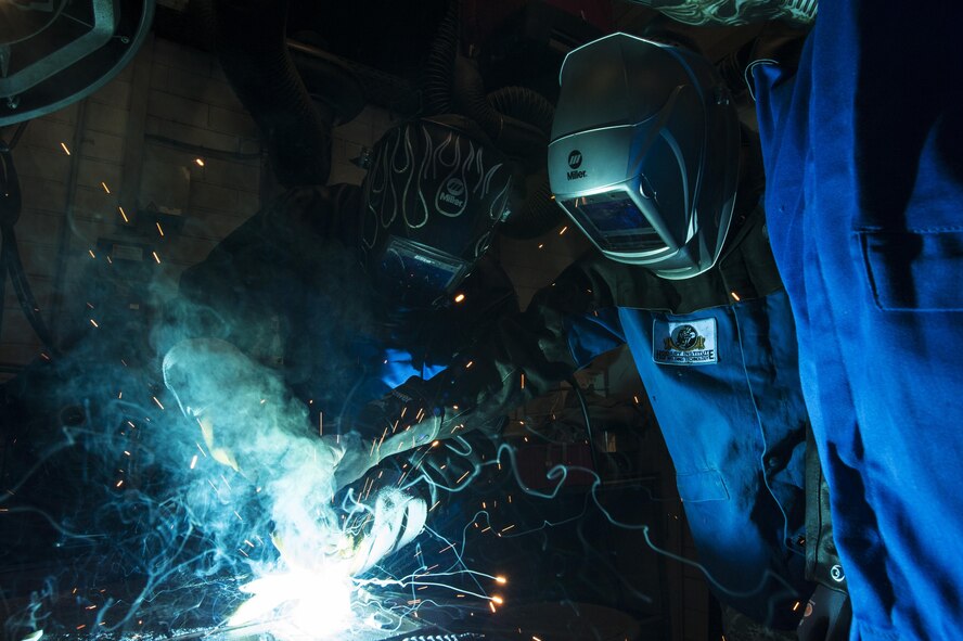 U.S. Air Force Col. Joseph McFall, 52nd Fighter Wing commander, center left, learns how to weld in the vehicle management special purpose shop at Spangdahlem Air Base, Germany, July 28, 2016. The 52nd FW commander and command chief had the opportunity to work alongside and learn firsthand what 52nd LRS vehicle management special purpose shop Airmen do. (U.S. Air Force photo
by Staff Sgt. Jonathan Snyder/Released)