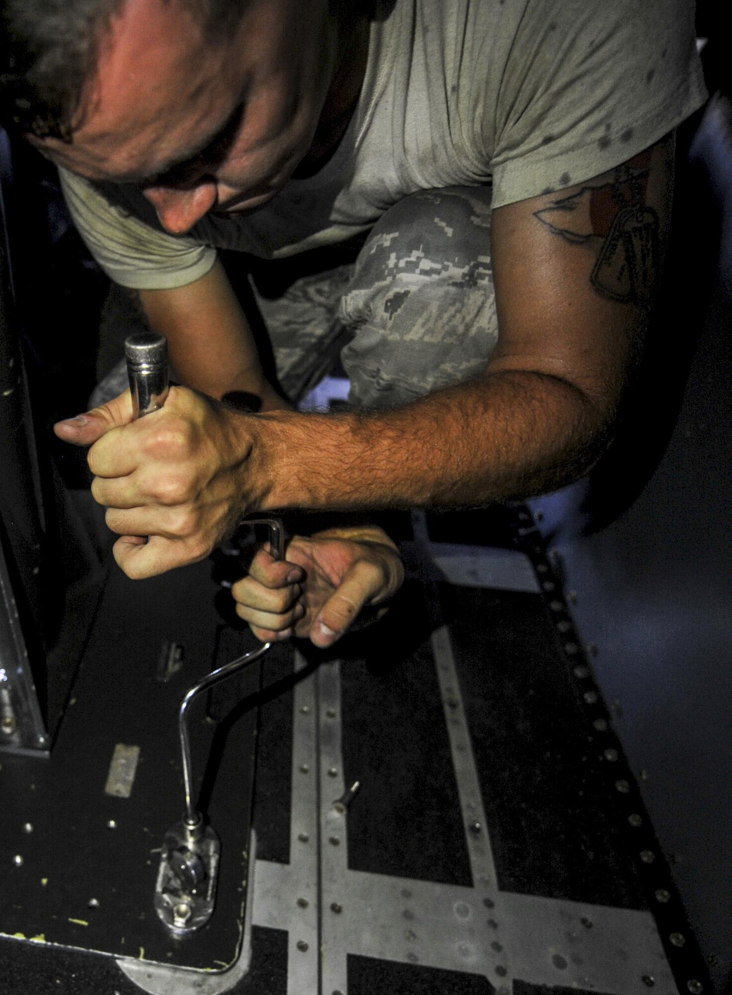 Senior Airman Seth Carnahan, a weapons load crew member with the 4th Aircraft Maintenance Unit, tightens a bolt at Hurlburt Field, Fla., July 20, 2016. Carnahan and his crew members uses an lifting fixture to safely install a Ammo Storage Handling System. The ASHS feeds ammunition to the 25mm cannon that is located inside the aircraft's cargo hold. (U.S. Air Force photo by Airman Dennis Spain)