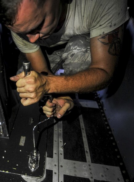 Senior Airman Seth Carnahan, a weapons load crew member with the 4th Aircraft Maintenance Unit, tightens a bolt at Hurlburt Field, Fla., July 20, 2016. Carnahan and his crew members uses an lifting fixture to safely install a Ammo Storage Handling System. The ASHS feeds ammunition to the 25mm cannon that is located inside the aircraft's cargo hold. (U.S. Air Force photo by Airman Dennis Spain)