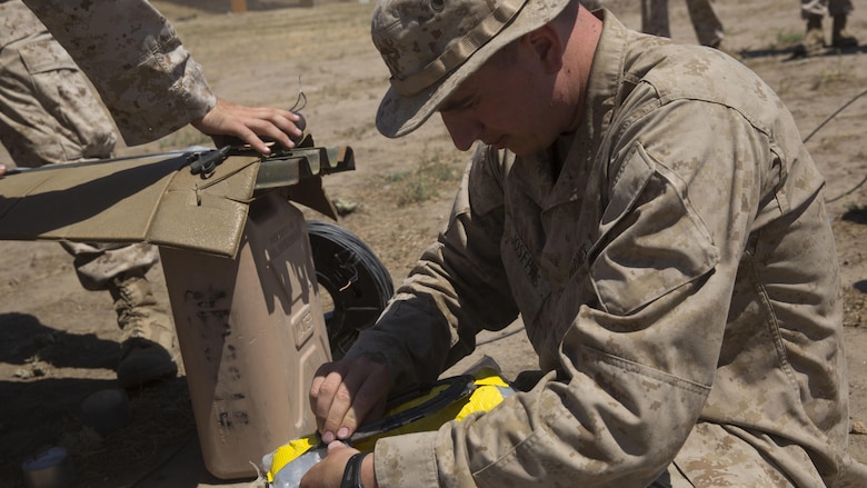 Lance Cpl. Jacob Joseph, a combat engineer, with 1st Battalion, 5th Marine Regiment, 1st Marine Division, builds a water charge for a breaching exercise at Camp Pendleton, California, July 26, 2016. Combat engineers with the unit worked closely with assaultmen and riflemen during a live-fire training exercise to teach them various methods to build improvised breaching charges. 