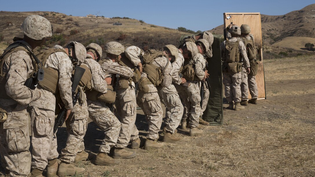 Marines from 1st Battalion, 5th Marine Regiment, 1st Marine Division, stack up behind a blast blanket in preparation for a door breach at Camp Pendleton, Califorina, July 26, 2016. Marine combat engineers, assaultmen and riflemen participated in the live-fire exercise to experience the integration of working together while keeping their focus on mission accomplishment.
