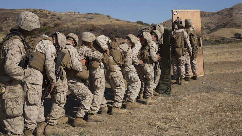 Marines from 1st Battalion, 5th Marine Regiment, 1st Marine Division, stack up behind a blast blanket in preparation for a door breach at Camp Pendleton, Califorina, July 26, 2016. Marine combat engineers, assaultmen and riflemen participated in the live-fire exercise to experience the integration of working together while keeping their focus on mission accomplishment.
