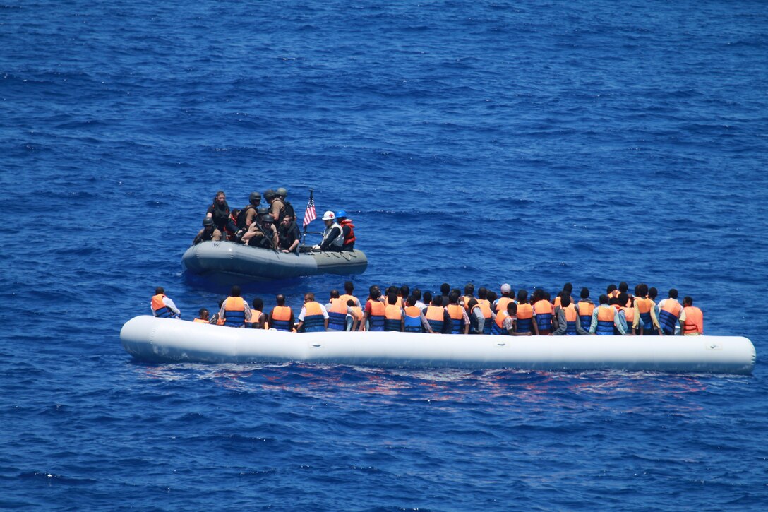 A team from the guided-missile destroyer USS Carney approaches a migrant vessel in the Mediterranean Ocean, July 29, 2016. The Carney, which provided food and water to the migrants before coordinating with a nearby merchant vessel to take them to safety, is patrolling in the U.S. 6th Fleet area of operations. Navy photo by ISC Wesley R. Dickey

