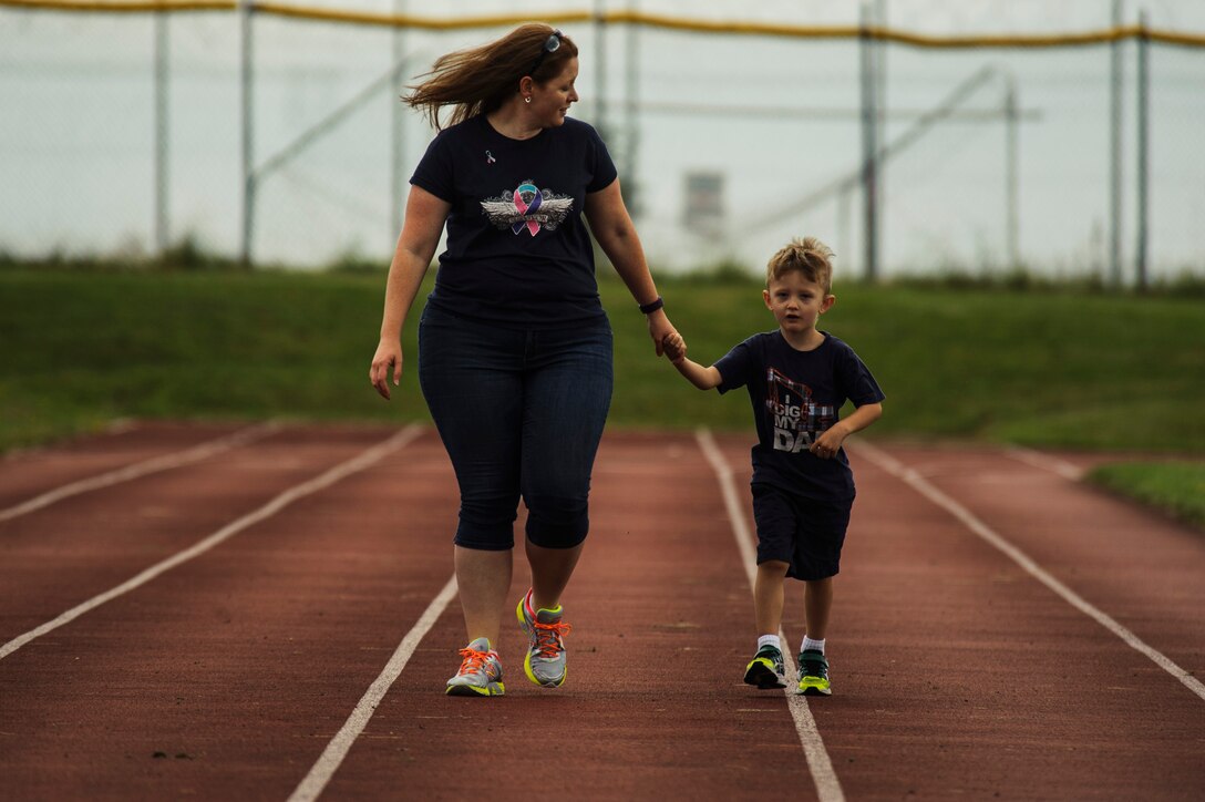Jennifer Hartzog, cancer survivor, walks with her son Sam Hartzog during Relay For Life at Spangdahlem Air Base, Germany, July 29, 2016. Airmen and their families raised more than $12,000 for the American Cancer Society during this 24-hour relay event. (U.S. Air Force photo by Staff Sgt. Jonathan Snyder/Released)