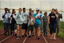 Airmen and family members walk during Relay For Life at Spangdahlem Air Base, Germany, July 29, 2016. Airmen and family members walk to honor cancer survivors and caregivers during the opening ceremony of this 24-hour relay event. (U.S. Air Force photo by Staff Sgt. Jonathan Snyder/Released)