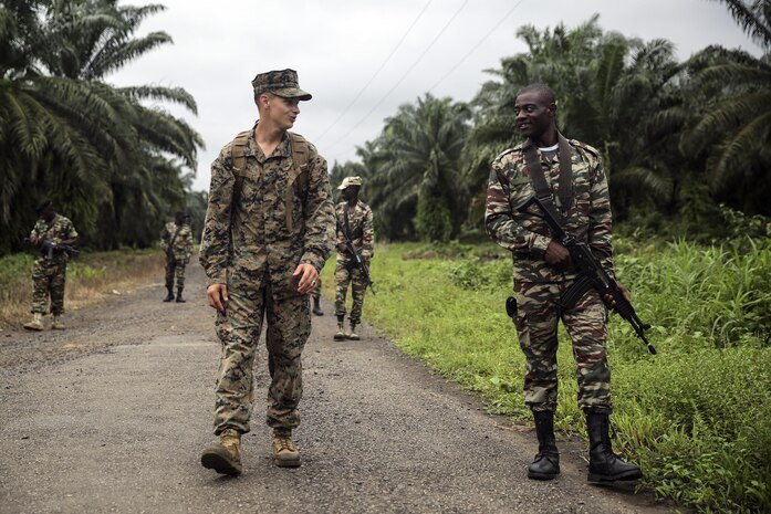 Cpl. Mitchell York, a rifleman with Special Purpose Marine Air-Ground Task Force Crisis Response-Africa, walks and talks with a Cameroonian soldier with Forces Fusiliers Marins et Palmeurs de Combat, during a patrolling exercise in Limbé, Cameroon, June 28, 2016.  Marines share tactics, techniques and skills with the FORFUMAPCO soldiers to combat the illicit trafficking in Cameroon.  (U.S. Marine Corps photo by Cpl. Alexander Mitchell/released)