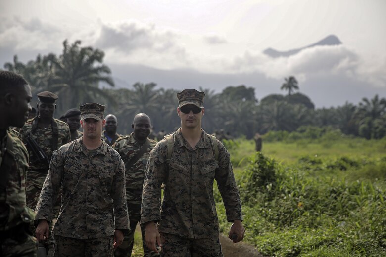 Cpl. Jeremy Osteen, a squad leader with Special Purpose Marine Air-Ground Task Force Crisis Response-Africa, , and Lance Cpl. Christopher Parsons, a rifleman with SPMAGTF-CR-AF, lead Cameroonian soldiers with Forces Fusiliers Marins et Palmeurs de Combat to a training area in Limbé, Cameroon, June 28, 2016.  Marines share tactics, techniques and skills with the FORFUMAPCO soldiers to combat the illicit trafficking in Cameroon.  (U.S. Marine Corps photo by Cpl. Alexander Mitchell/released)