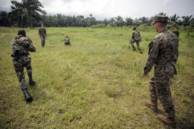 Cpl. Mitchell York, a rifleman with Special Purpose Marine Air-Ground Task Force Crisis Response-Africa, watches as Cameroonian soldiers with Forces Fusiliers Marins et Palmeurs de Combat, conduct buddy rushes in Limbé, Cameroon, June 28, 2016.  Marines share tactics, techniques and skills with the FORFUMAPCO soldiers to combat the illicit trafficking in Cameroon.  (U.S. Marine Corps photo by Cpl. Alexander Mitchell/released)