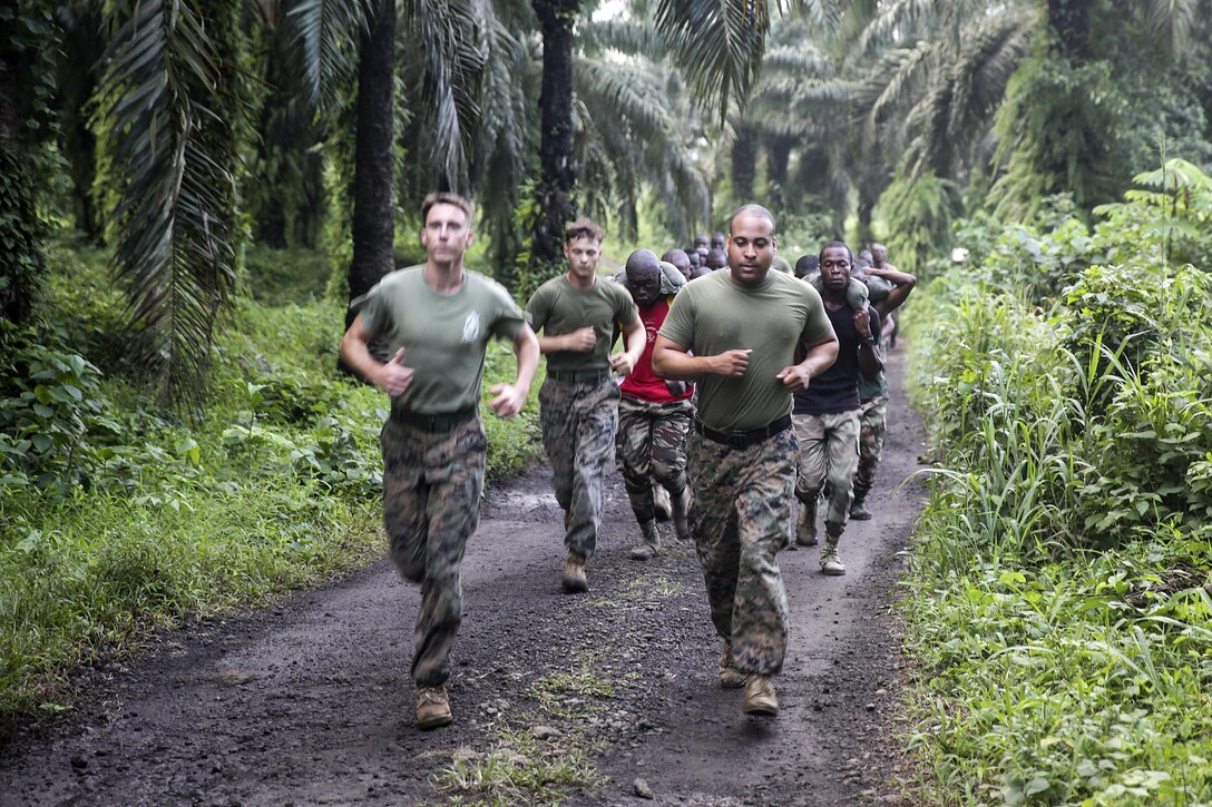 Three Marines with Special Purpose Marine Air-Ground Task Force Crisis Response-Africa, run with Cameroonian soldiers with Forces Fusiliers Marins et Palmeurs de Combat during a physical training exercise in Limbé, Cameroon, June 29, 2016.  Marines share tactics, techniques and skills with the FORFUMAPCO soldiers to combat the illicit trafficking in Cameroon.  (U.S. Marine Corps photo by Cpl. Alexander Mitchell/released)