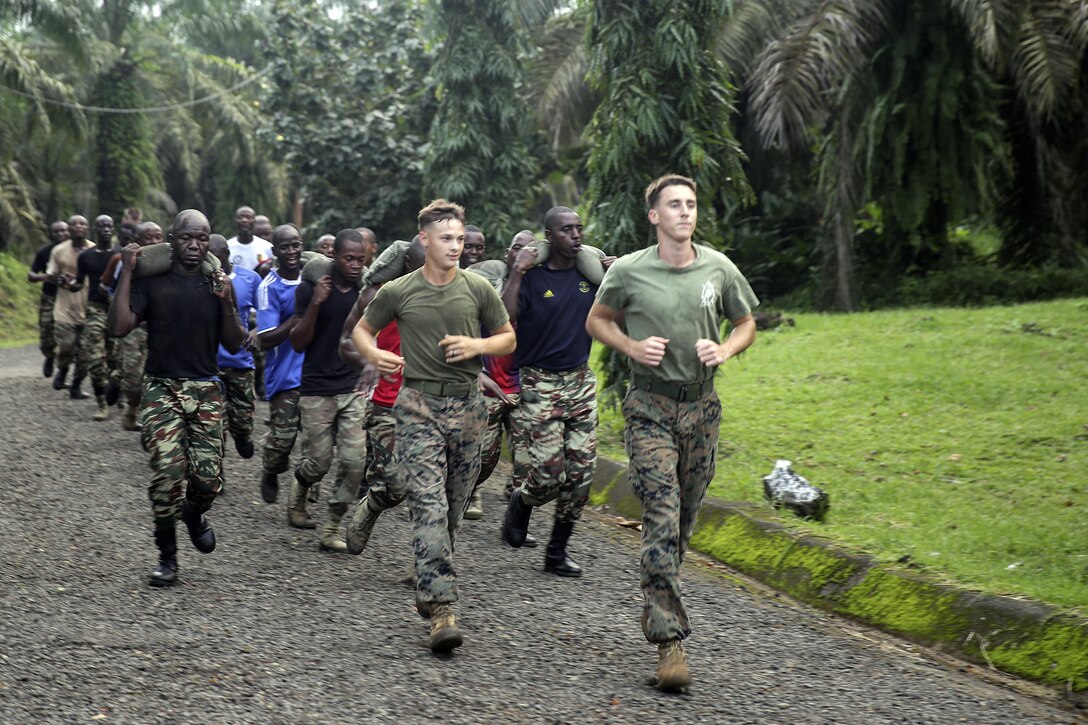 Two Marines with Special Purpose Marine Air-Ground Task Force Crisis Response-Africa, run with Cameroonian soldiers with Forces Fusiliers Marins et Palmeurs de Combat during a physical training exercise in Limbé, Cameroon, June 29, 2016.  Marines share tactics, techniques and skills with the FORFUMAPCO soldiers to combat the illicit trafficking in Cameroon.  (U.S. Marine Corps photo by Cpl. Alexander Mitchell/released)