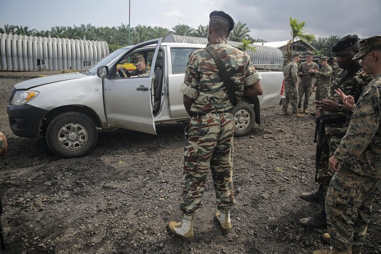 A Cameroonian soldier with Fusiliers Marins et Palmeurs de Combat, tells Lance Cpl. Dustin Kitts, a rifleman with Special Purpose Marine Air-Ground Task Force Crisis Response-Africa, to exit the truck during a vehicle search exercise in Limbé, Cameroon, June 30, 2016.  Marines share tactics, techniques and skills with the FORFUMAPCO soldiers to combat the illicit trafficking in Cameroon.  (U.S. Marine Corps photo by Cpl. Alexander Mitchell/released)