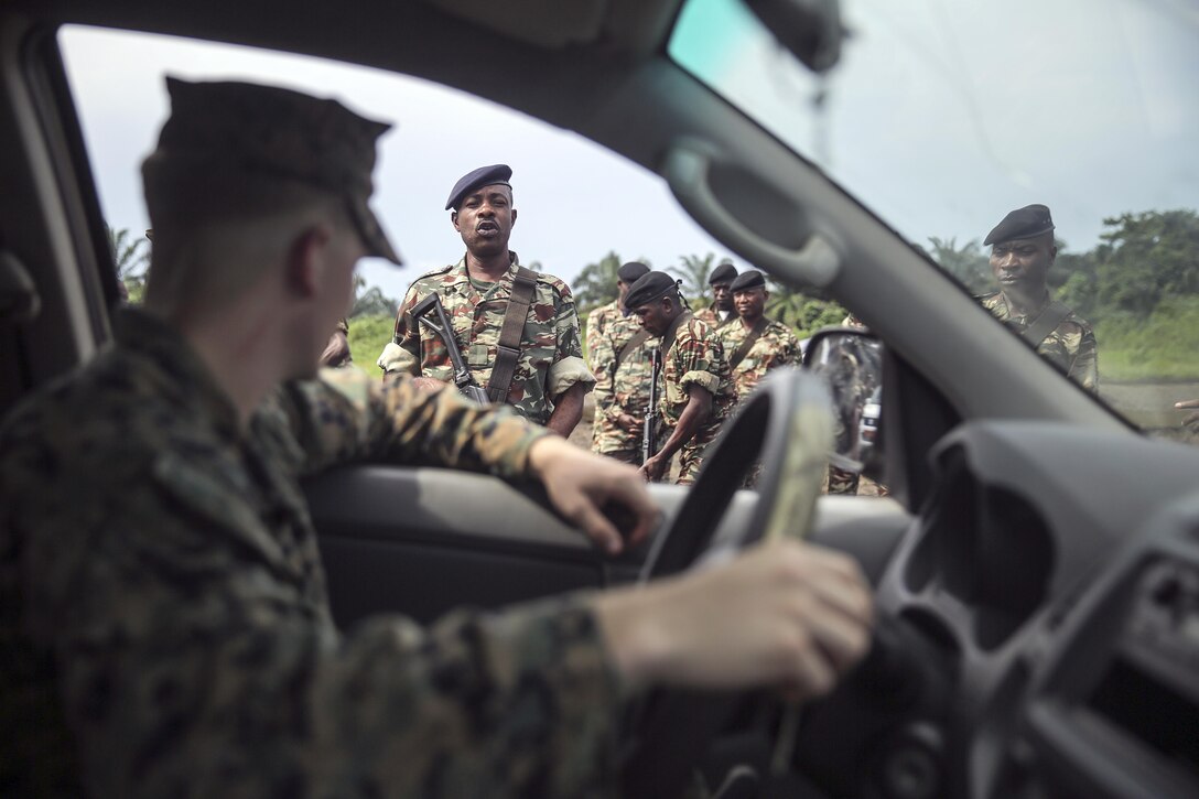 A Cameroonian soldier with Fusiliers Marins et Palmeurs de Combat, tells Lance Cpl. Dustin Kitts, a rifleman with Special Purpose Marine Air-Ground Task Force Crisis Response-Africa, to exit the truck during a vehicle search exercise in Limbé, Cameroon, June 30, 2016.  Marines share tactics, techniques and skills with the FORFUMAPCO soldiers to combat the illicit trafficking in Cameroon.  (U.S. Marine Corps photo by Cpl. Alexander Mitchell/released)
