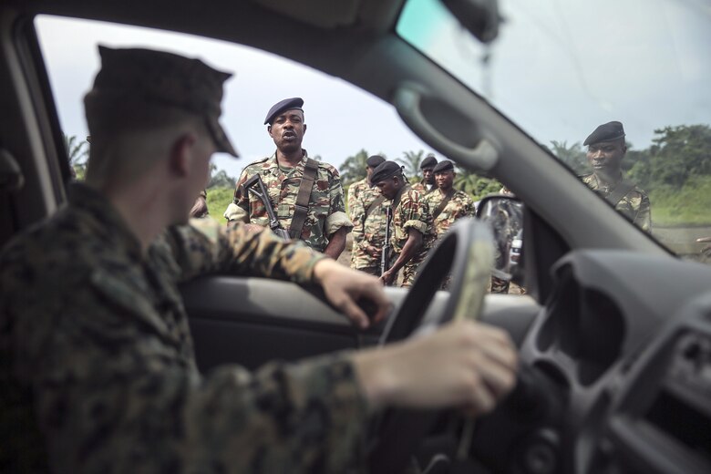 A Cameroonian soldier with Fusiliers Marins et Palmeurs de Combat, tells Lance Cpl. Dustin Kitts, a rifleman with Special Purpose Marine Air-Ground Task Force Crisis Response-Africa, to exit the truck during a vehicle search exercise in Limbé, Cameroon, June 30, 2016.  Marines share tactics, techniques and skills with the FORFUMAPCO soldiers to combat the illicit trafficking in Cameroon.  (U.S. Marine Corps photo by Cpl. Alexander Mitchell/released)