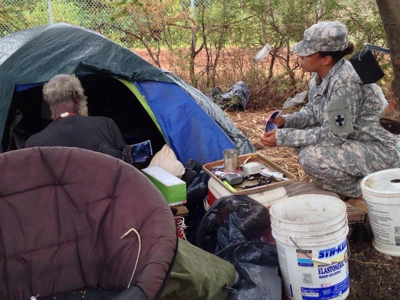 Army Sgt. 1st Class Nicole Howell, 8th Theater Sustainment Command public affairs operations noncommissioned officer, talks with a homeless veteran ahead of the annual Veterans Stand-Down in Honolulu, Aug. 5, 2015. The stand-down was part of the Mayors Challenge to End Veteran Homelessness initiative announced by First Lady Michelle Obama as a way to challenge the mayors in major cities to provide services and supplies to homeless veterans such as food, shelter, clothing, medical, dental and benefits counseling with the hope of getting them off the streets. Courtesy photo