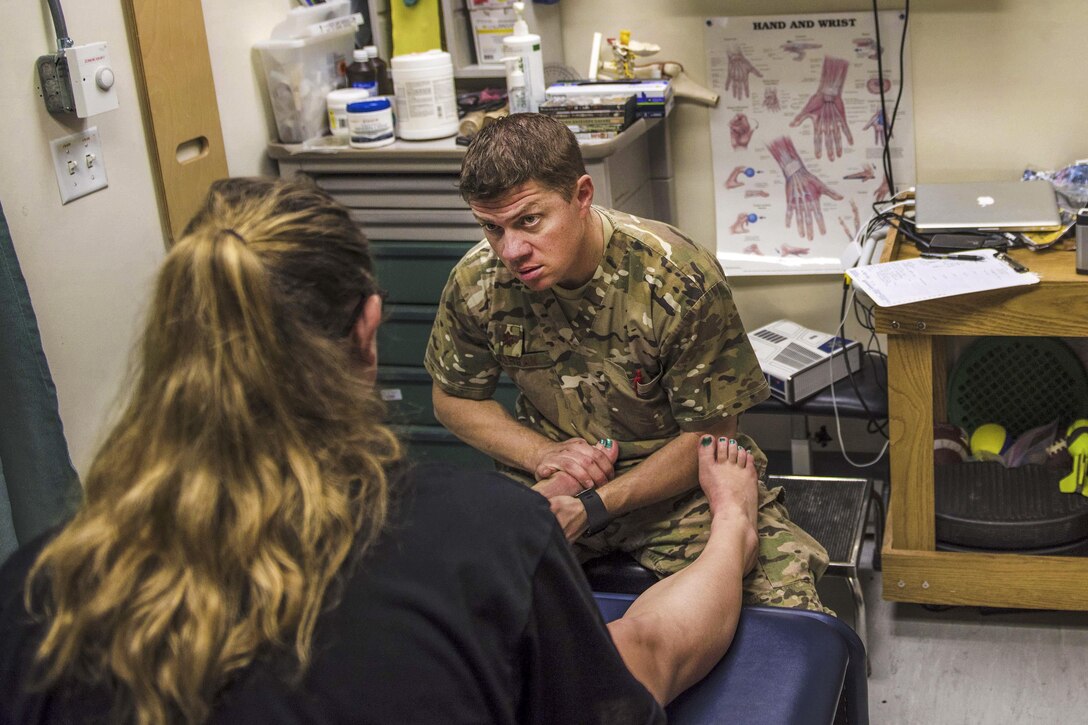 Air Force Maj. Brandon Morgan examines an Army specialist at Bagram Airfield, Afghanistan, July 19, 2016. Morgan, a physical therapist assigned to the 455th Expeditionary Medical Group, helps patients reduce pain and improve or restore mobility. Air Force photo by Senior Airman Justyn M. Freeman