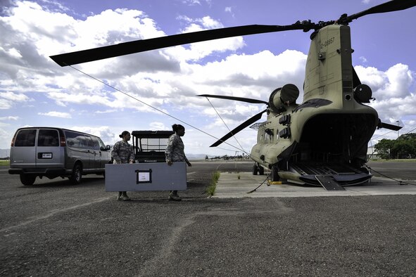 Capt. Amber El-Amin, a Joint Task Force-Bravo operations medical planner, and Senior Airman Synethia Robinson, the JTF-Bravo medical operations NCO in charge, help load equipment into a CH-47 Chinook helicopter July 25, 2016 at Soto Cano Air Base, Honduras. El-Amin and Robinson play a vital role in the joint operations planning process for JTF-Bravo missions. (U.S. Air Force photo/Staff Sgt. Siuta B. Ika)