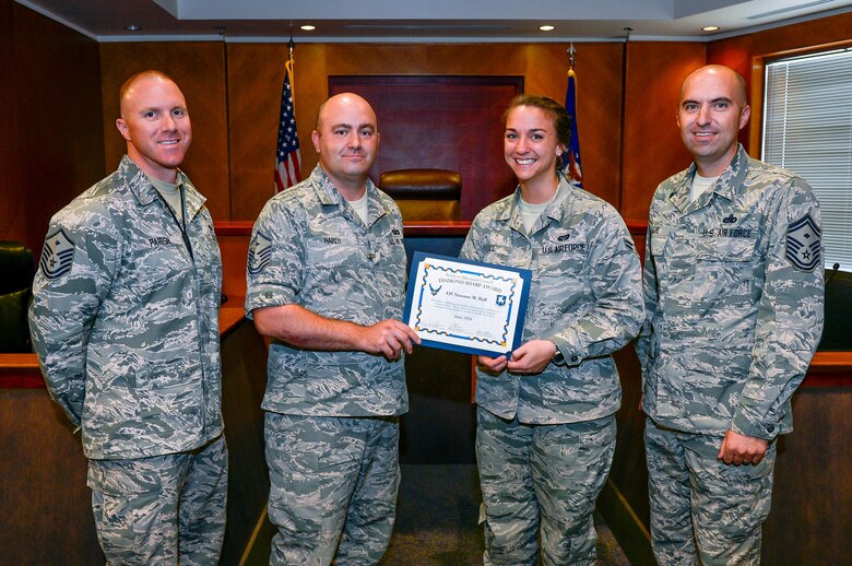 Master Sgt. Zachary Parish, 50th Security Forces Squadron first sergeant, Master Sgt. Joseph Hardy, 50th Network Operations Group first sergeant, and Senior Master Sgt. Allen Levie, 50th Operations Group first sergeant, present Airman 1st Class Suzanne Hall with the June 2016 Diamond Sharp Award at Schriever Air Force Base, Colorado, July 26, 2016. The intent of the Diamond Sharp Award is to recognize individuals that demonstrate outstanding performance and professionalism on a daily basis. 

As a military justice paralegal, Airman 1st Class Suzanne Hall's professional management of court cases and meticulous case preparation proved vital during a time where she was the only paralegal in the section. Hall displayed exemplary initiative as she conducted nearly 40 witness interviews. Furthermore, her proactive management of nonjudicial punishment actions led to 100 percent of the Article 15s being completed in less than 30 days, exceeding both the Air Force-wide goal of completion within 39 days. 
She is a tremendous asset to the legal office, its customers and all Schriever first sergeants. (U.S. Air Force photo/Christopher DeWitt)