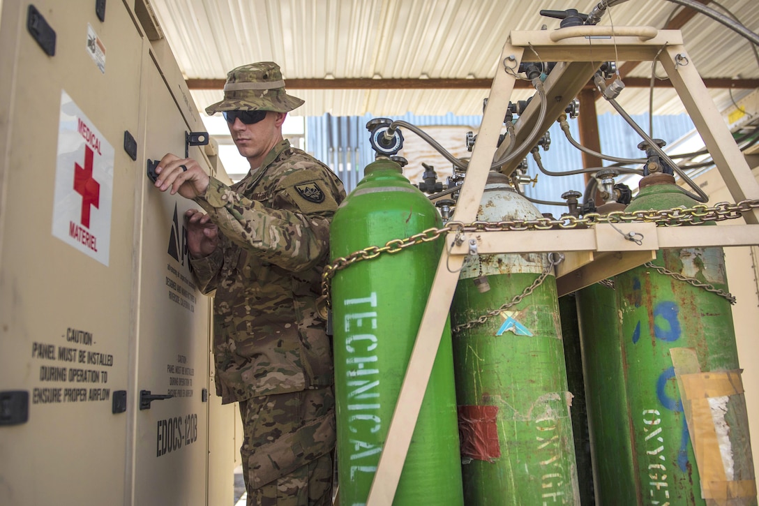 Air Force Staff Sgt. James Hughes checks a deployable oxygen concentration system at Bagram Airfield, Afghanistan, July 18, 2016. Hughes is a biomedical equipment technician assigned to the 455th Expeditionary Medical Group. The system intakes outside air, filters out the nitrogen and carbon dioxide, and produces 93-percent medical oxygen for patients. Air Force photo by Senior Airman Justyn M. Freeman