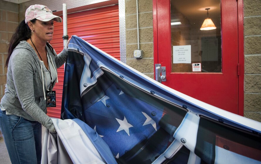 Christa Leary assembles a Kiss banner in the meet and greet area before the band's concert in Cheyenne, Wyoming.