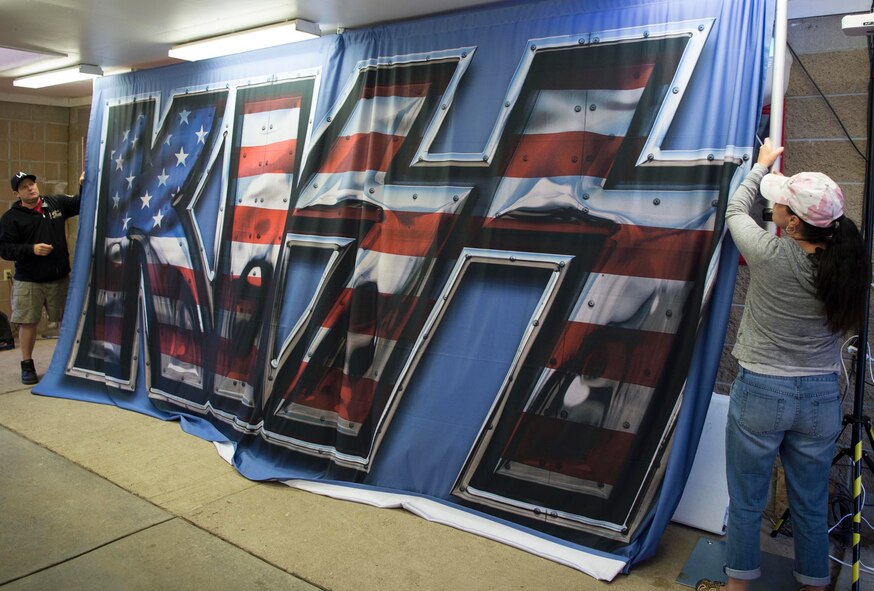 Dean Snowden, Kiss ambassador, and Christa Leary assemble a Kiss banner in the meet and greet area before the band's concert at Cheyenne Frontier Days in Cheyenne, Wyoming.