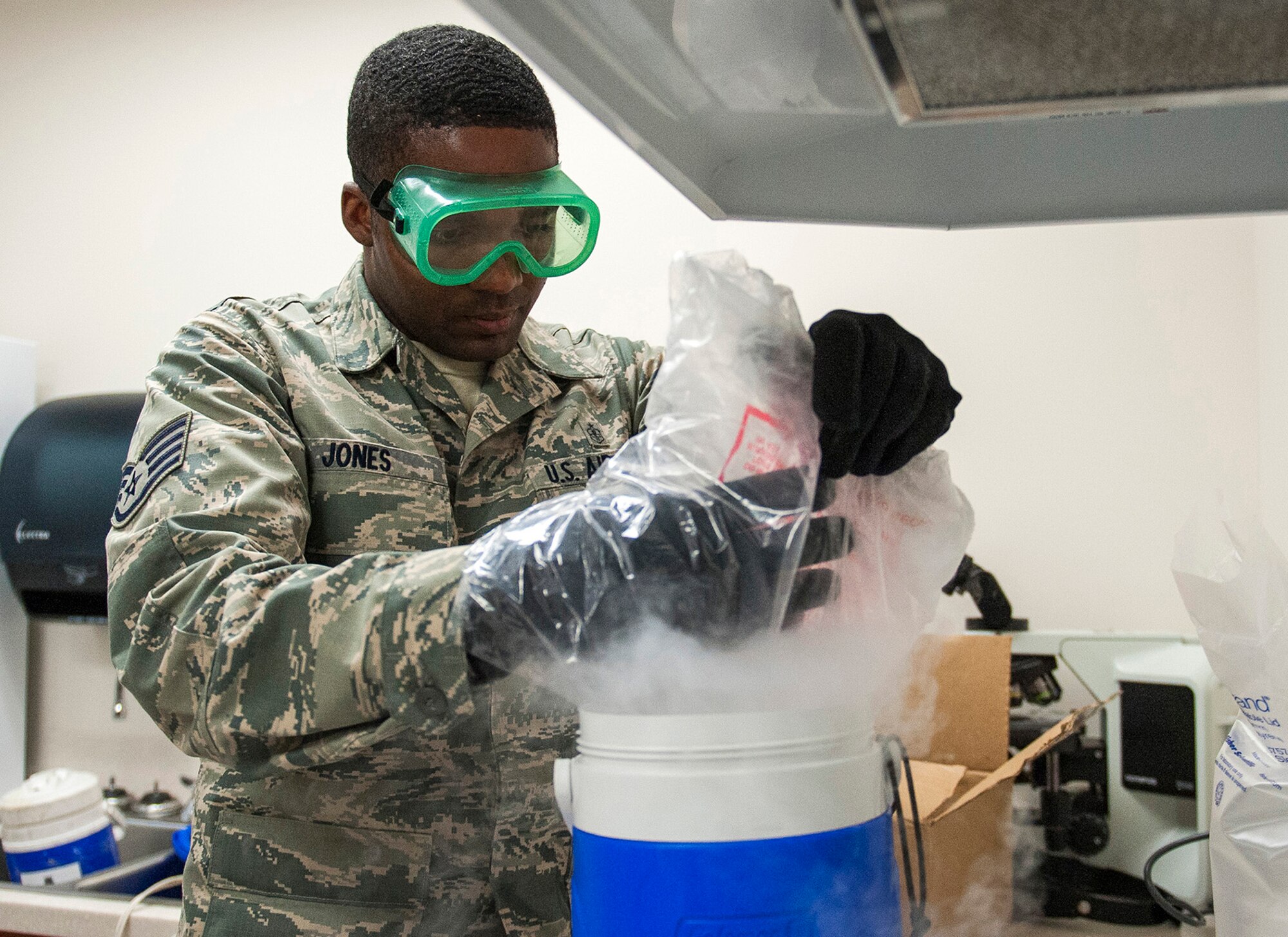 Staff Sgt. Derrick Jones, 96th Aerospace Medicine Squadron public health technician, drops dry ice into the carbon dioxide cooler July 20 at Eglin Air Force Base, Fla. Mosquitoes are attracted to the carbon dioxide that mammals exhale. The cooler emits carbon dioxide and is hung beside the traps.  The carbon dioxide attracts mosquitoes and lures them into the trap. (U.S. Air Force photo/Ilka Cole) 